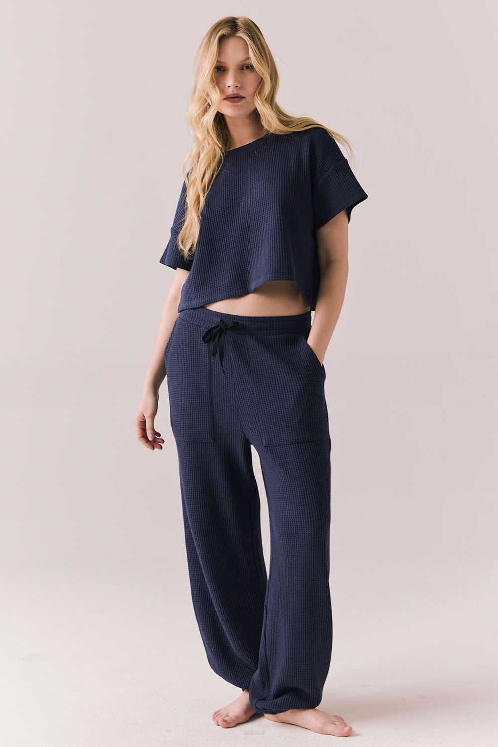 Full body view of model in Billyy Joggers in midnight blue with matching top.