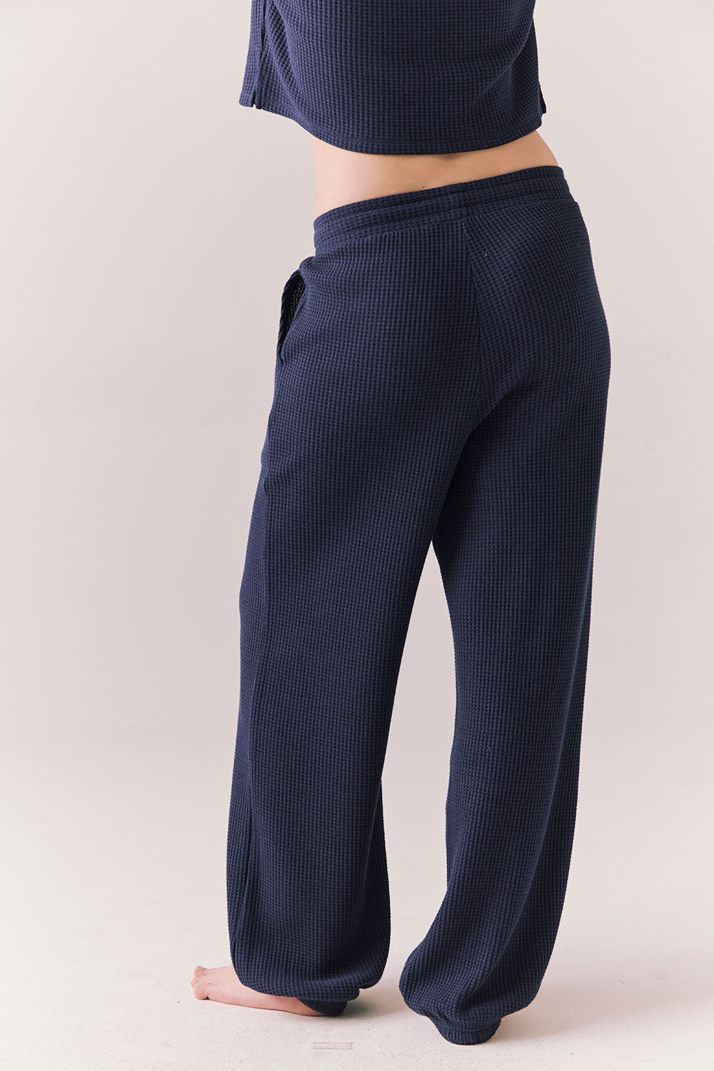 Back view of model wearing Billyy Joggers in midnight blue