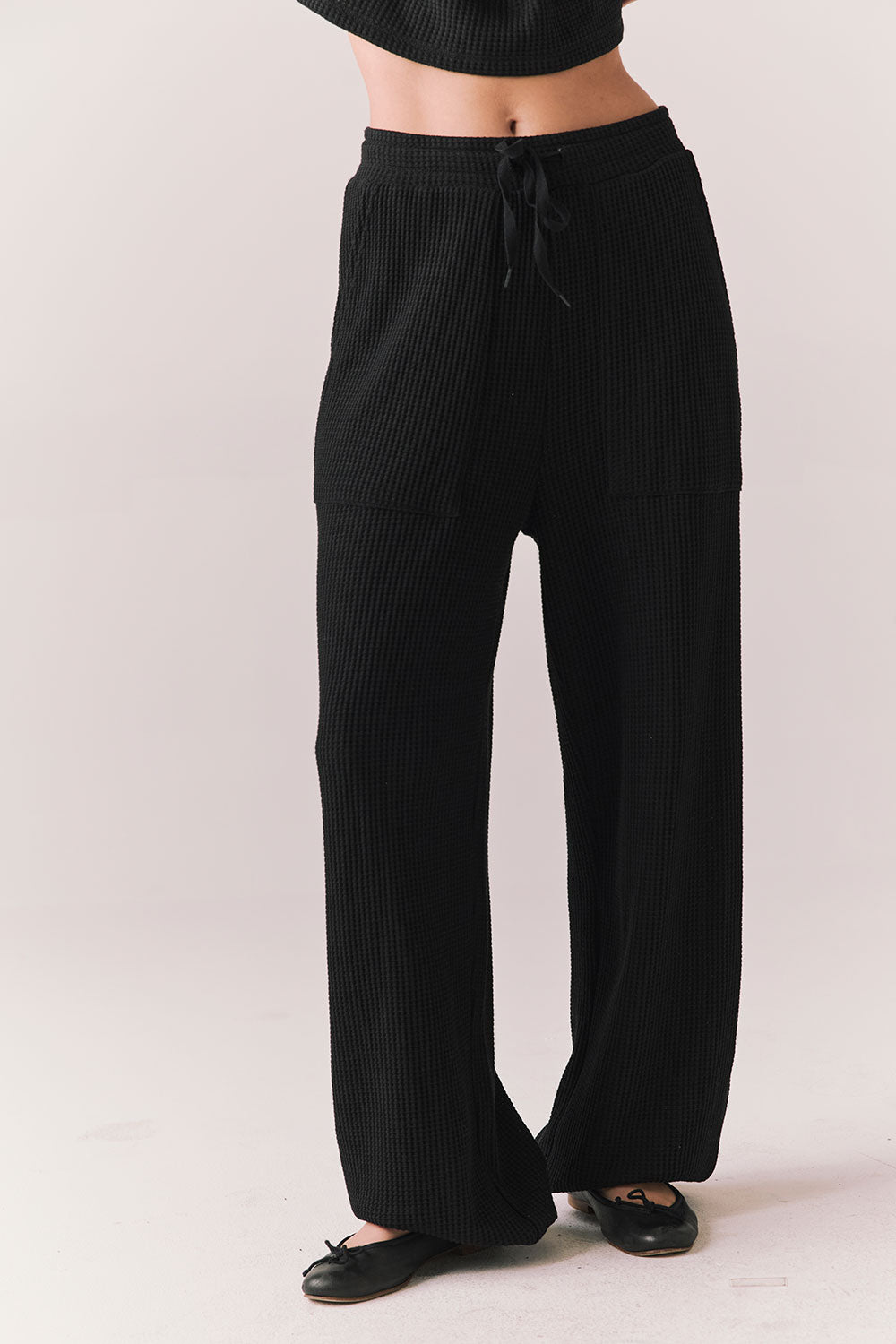Front view of model wearing Billyy Joggers in true black