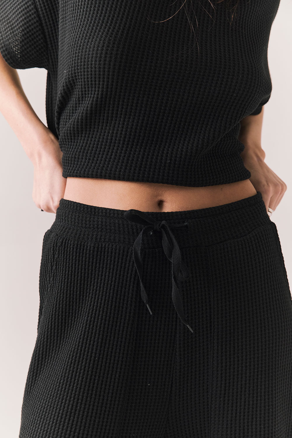 Closeup front view of model wearing Billyy Joggers in true black