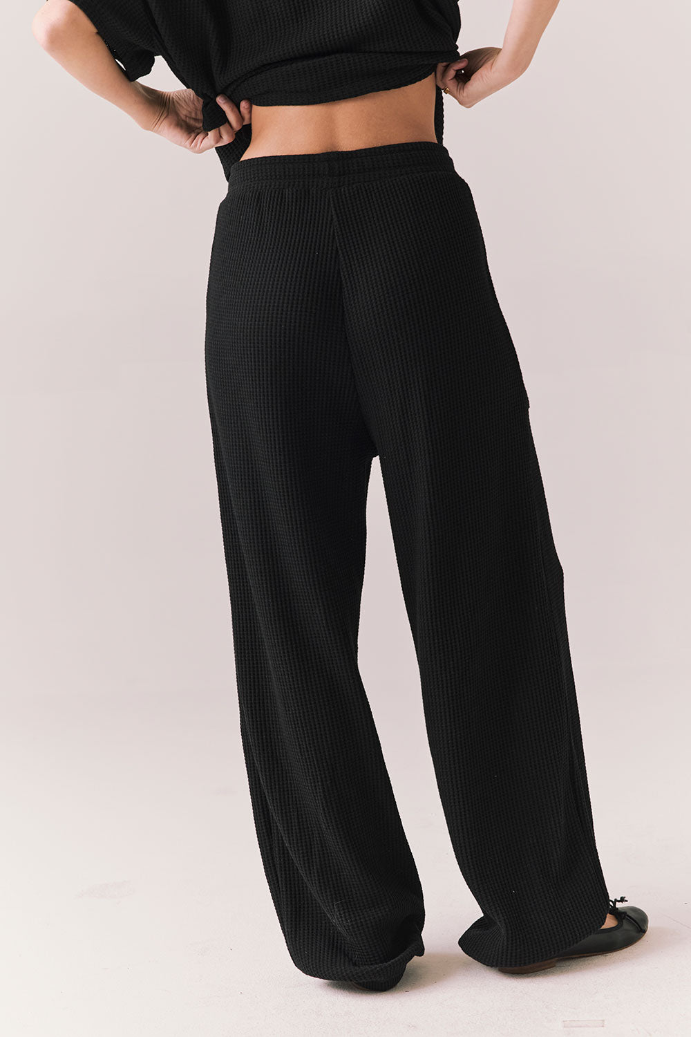 Back view of model wearing Billyy Joggers in true black