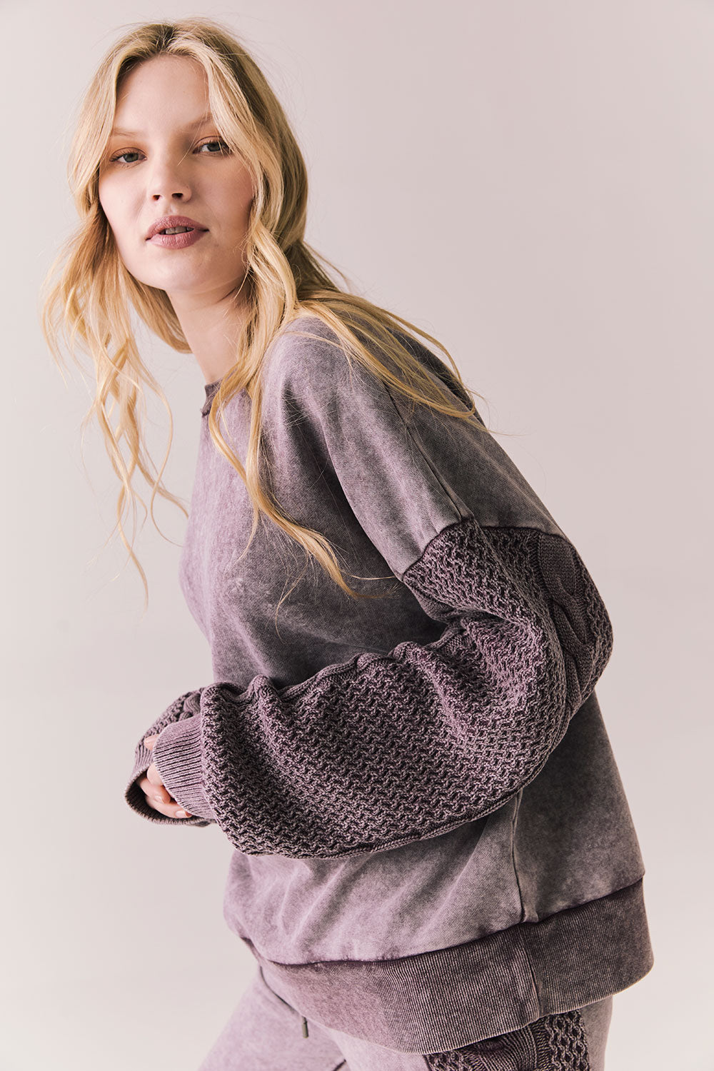 Side view of Maritime Pullover in fig (deep purple) with relaxed fit and knit texture against a plain background
