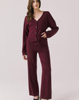 Full body view of woman wearing Chaser’s Lilou Purple Fig Joggers with matching Maison Cardigan on a plain background