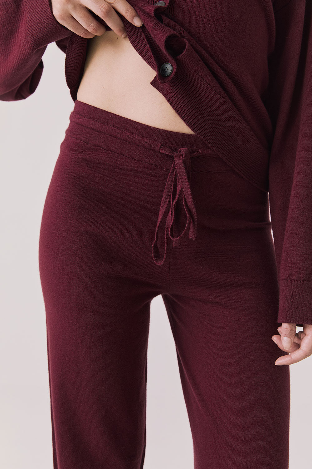 Front view of woman wearing Chaser’s Lilou Purple Fig Joggers on a plain background.