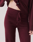 Front view of woman wearing Chaser’s Lilou Purple Fig Joggers on a plain background.