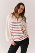 White zip-up pullover sweatshirt with red stripes and heart patch on sleeve.