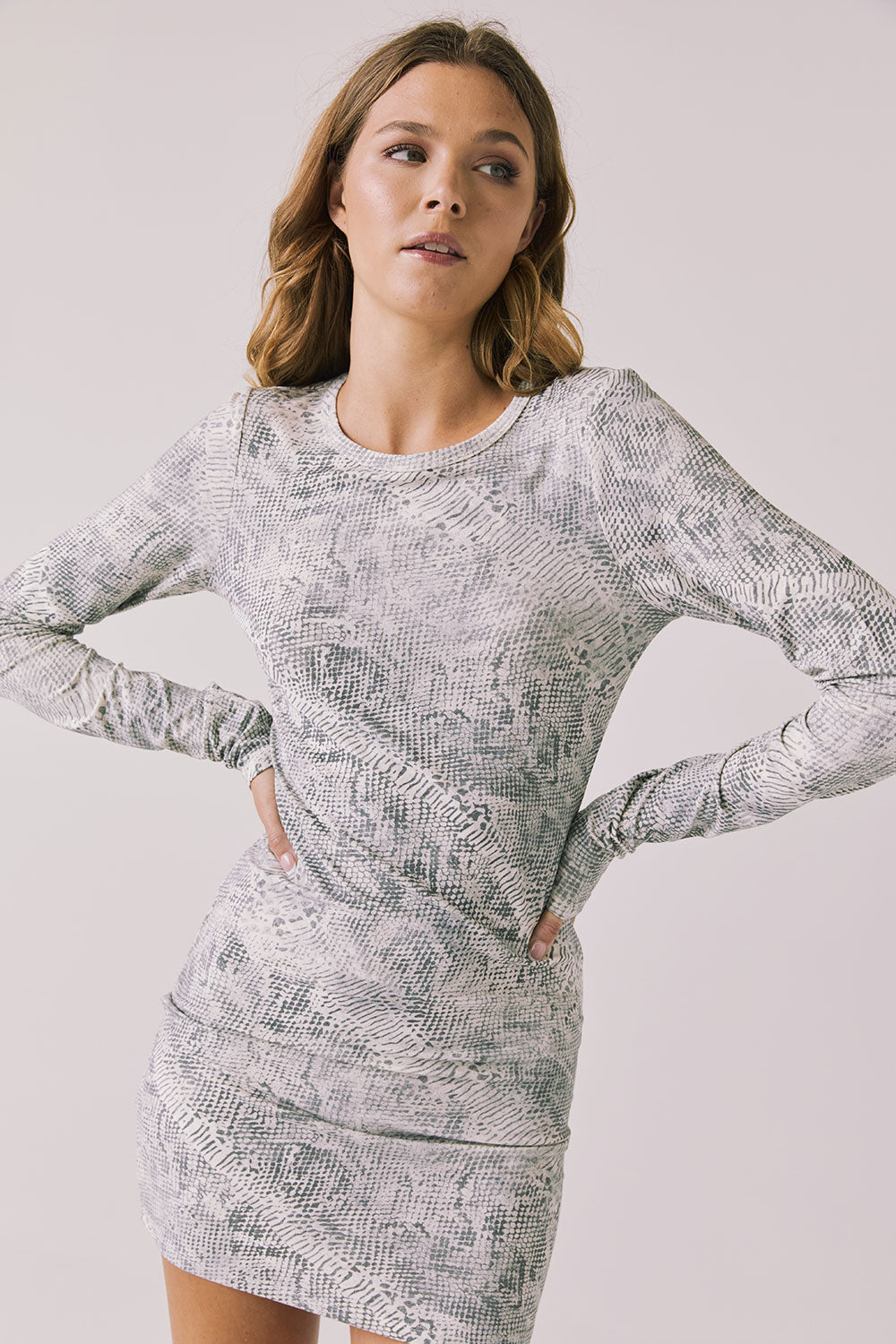 Front view of woman wearing Chaser’s Ziggy Python Print Mini Dress with subtle snakeskin pattern on a white background