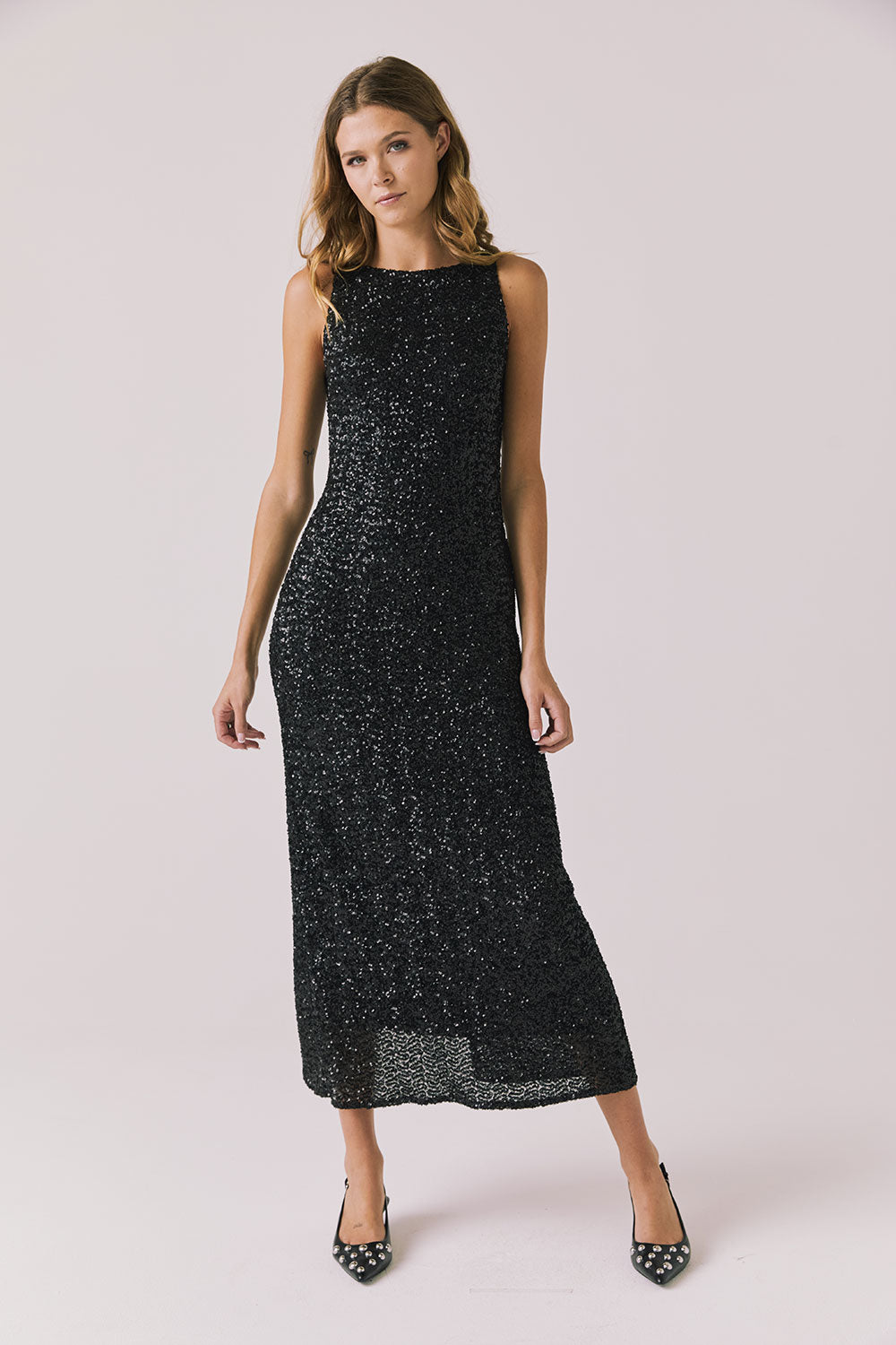 Full body view of woman wearing Chaser’s Faye True Black Dress on a white background