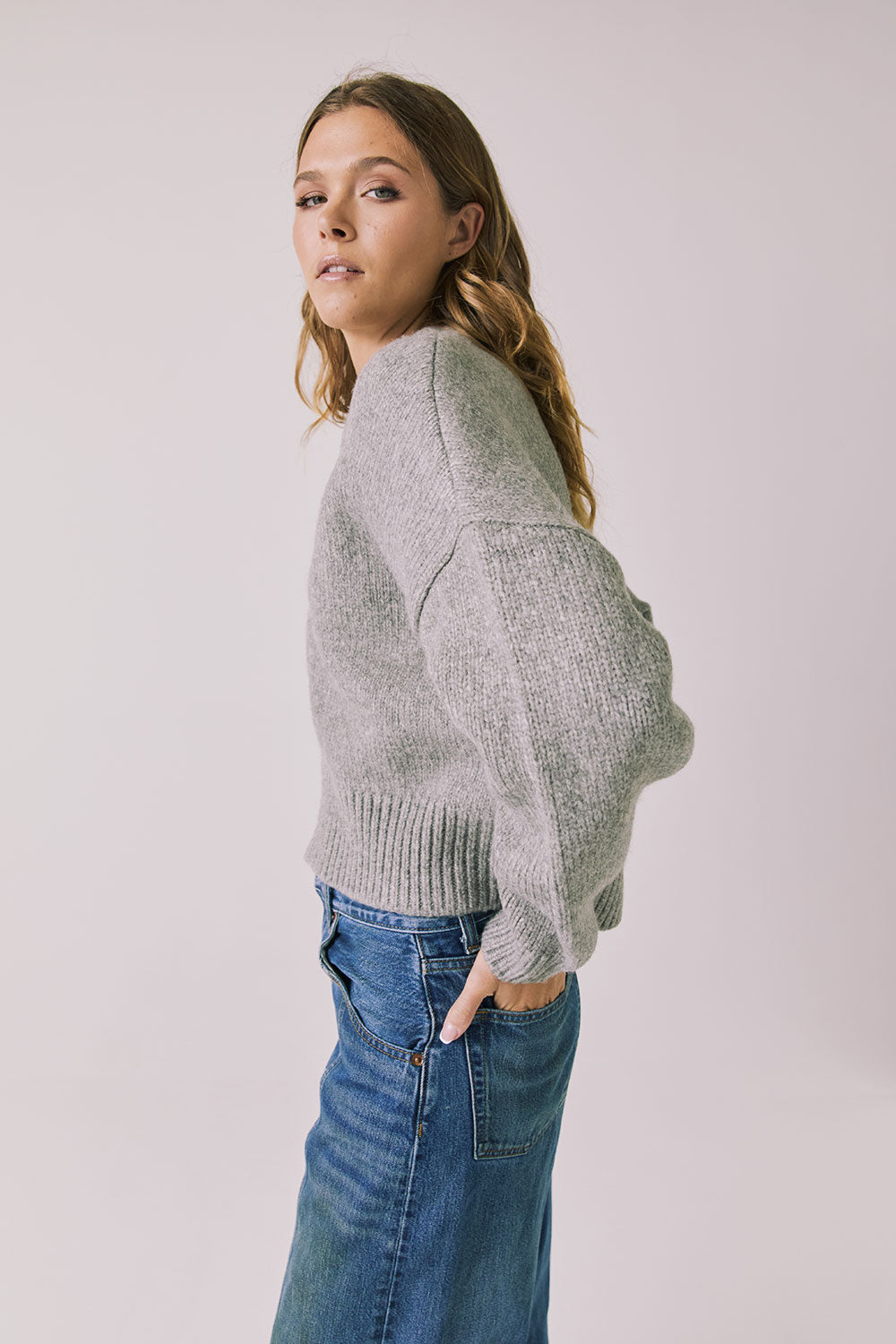 Side view of woman wearing Chaser’s Heather Grey Luck Zip Up Cardigan Sweater on a white background