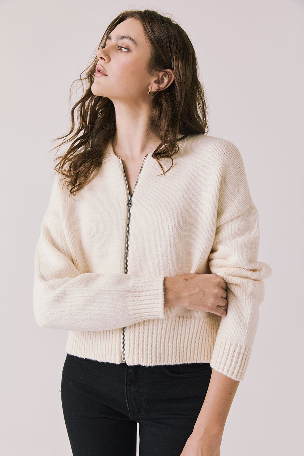 Front view of woman wearing Chaser’s Warm White Luck Zip Up Cardigan Sweater on a white background