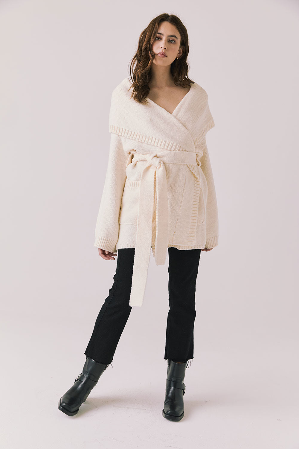 Full body view of woman wearing Chaser’s Eclipse Warm White Cardigan Robe styled with black jeans and boots on a white background