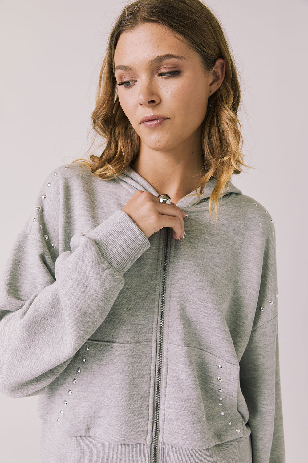 Front view of woman wearing Chaser’s Kiki Heather Grey Zip Up Hoodie on a white background