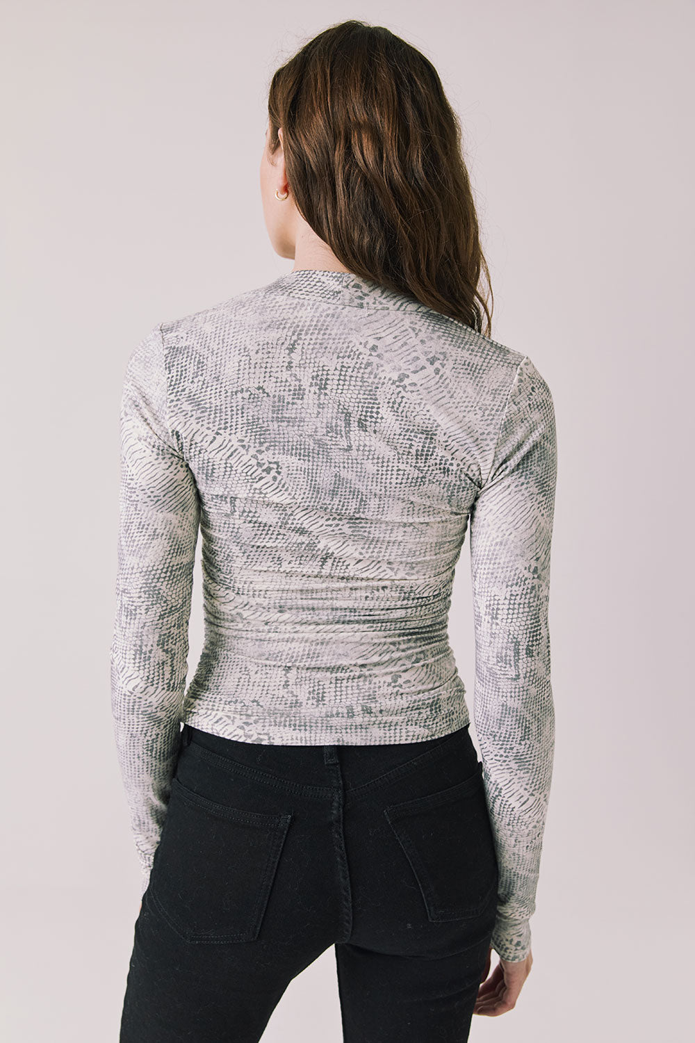 Back view of woman wearing Chaser’s Tilly Python Print Long Sleeve on a plain background