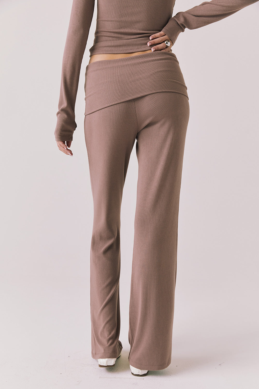 Back view of woman wearing Chaser’s Deep Taupe Mantra Legging on a plain background