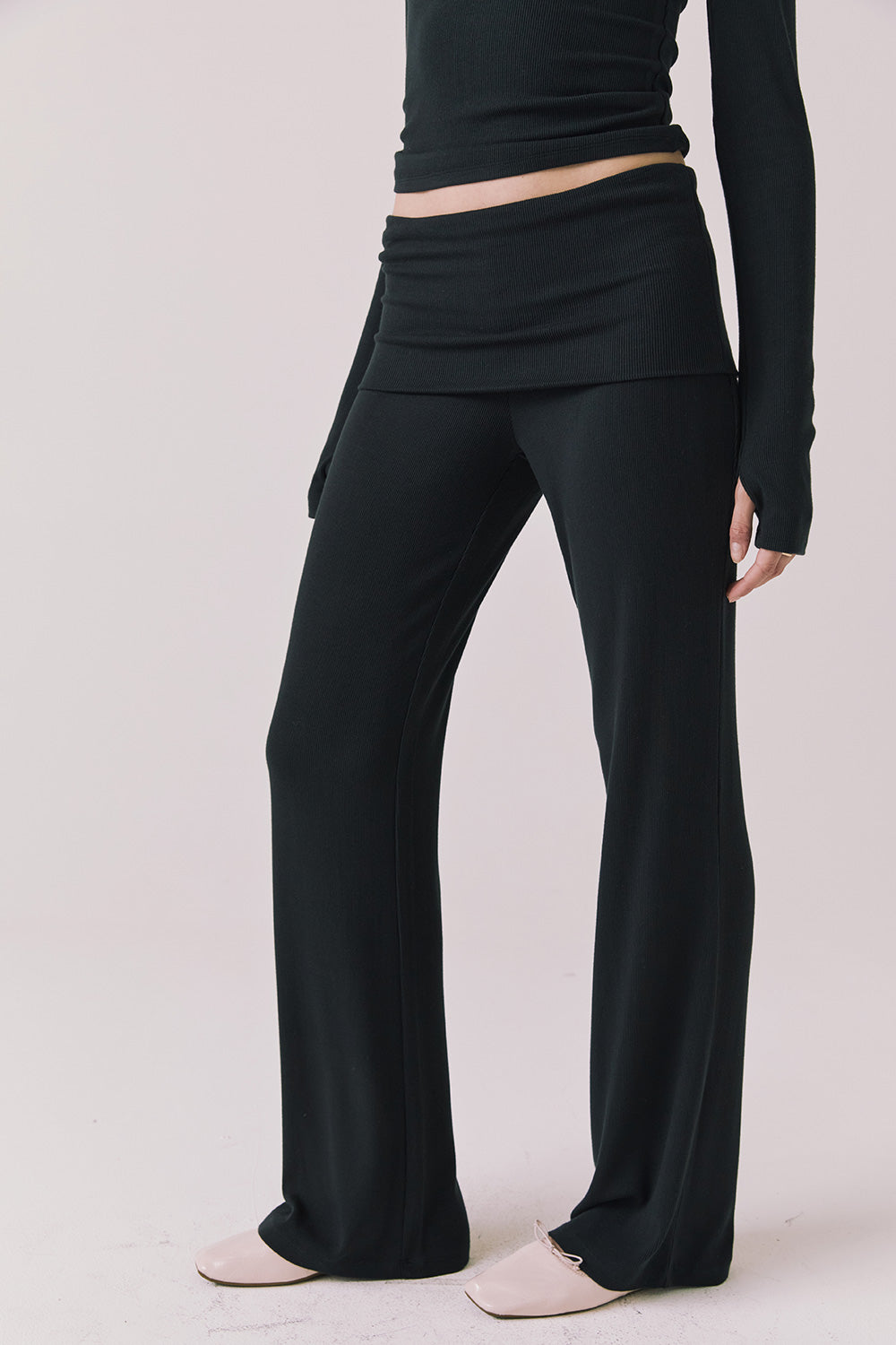Side view of woman wearing Chaser’s True Black Mantra Legging on a plain background