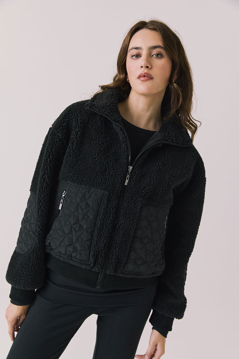 Front view of woman wearing Chaser’s Juno True Black Fleece Jacket on a plain background