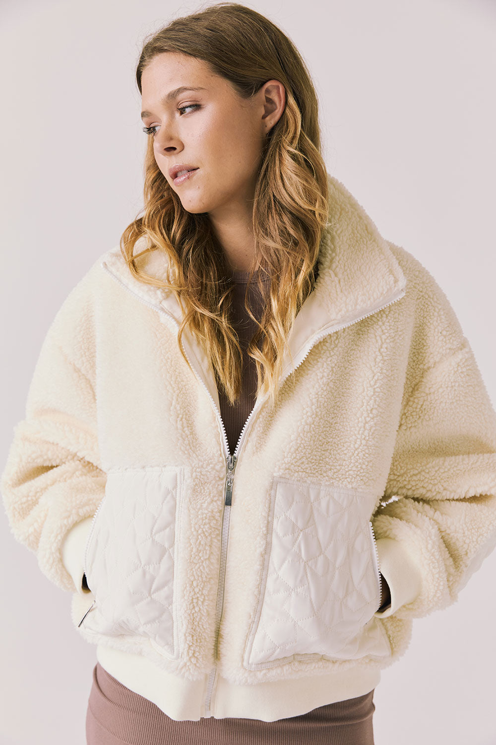 Front view of woman wearing Chaser’s Juno Warm White Fleece Jacket on a plain background