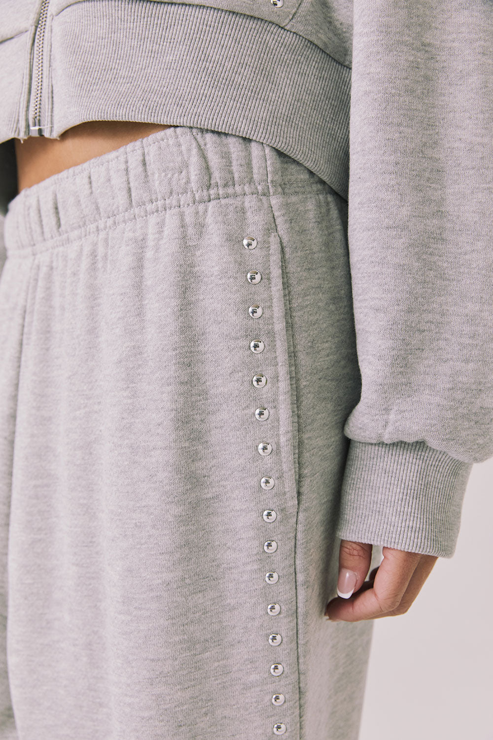 Side view of woman wearing Chaser’s Daze Heather Grey Joggers and sequin details on a white background