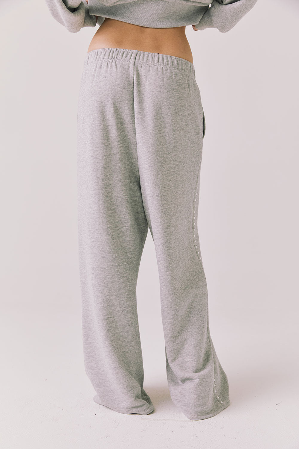 Back view of woman wearing Chaser’s Daze Heather Grey Joggers on a white background