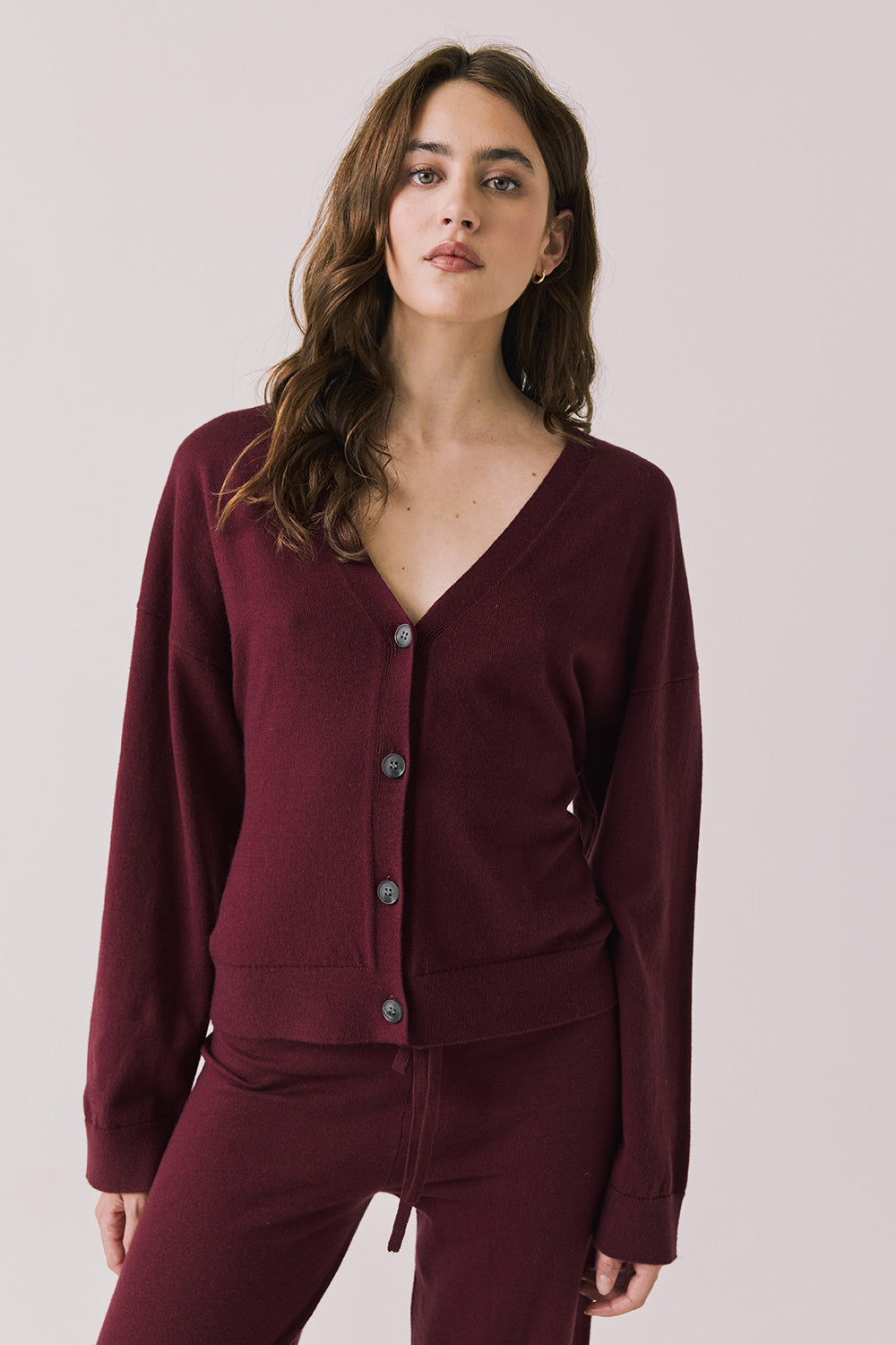 Front view of woman wearing Chaser’s Purple Fig Maison Cardigan Sweater on a white background