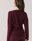 Back view of woman wearing Chaser’s Purple Fig Maison Cardigan Sweater on a white background