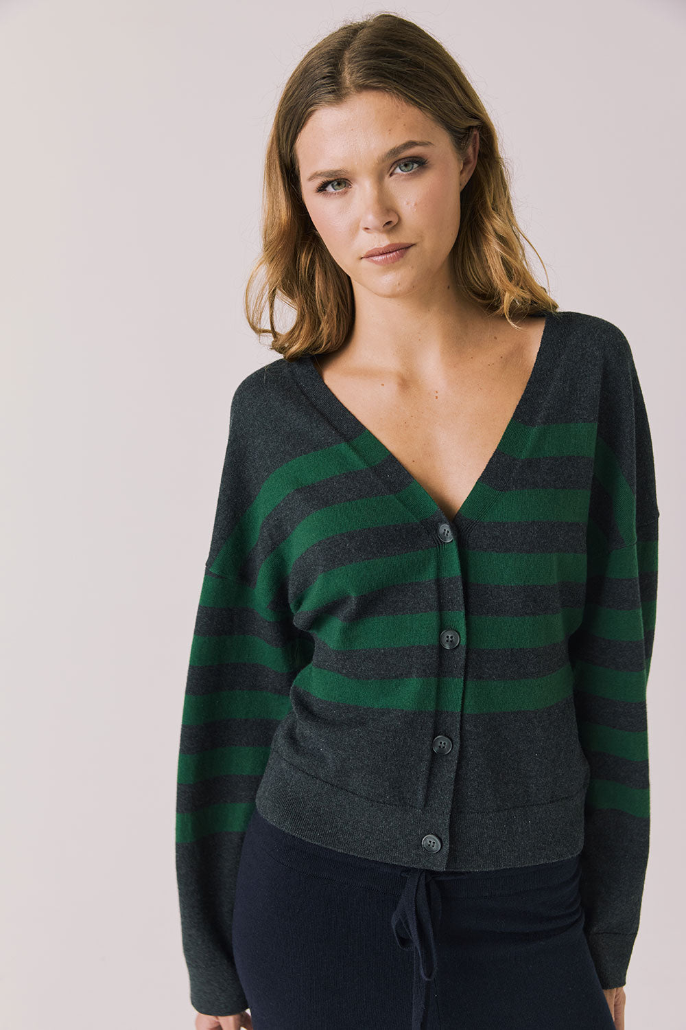 Front view of woman wearing Chaser’s Timeless Stripe Maison Cardigan Sweater on a white background