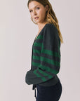 Side view of woman wearing Chaser’s Timeless Stripe Maison Cardigan Sweater on a white background