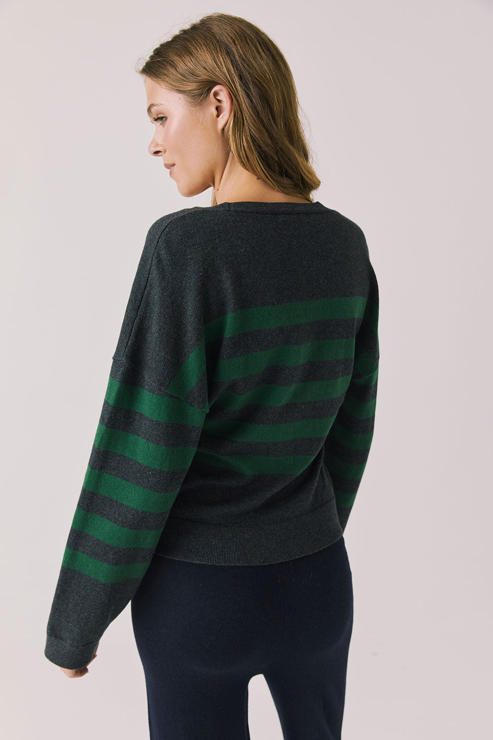 Back view of woman wearing Chaser’s Timeless Stripe Maison Cardigan Sweater on a white background