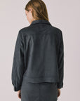 Back view of woman wearing Chaser’s Dusk True Black Jacket on a light background