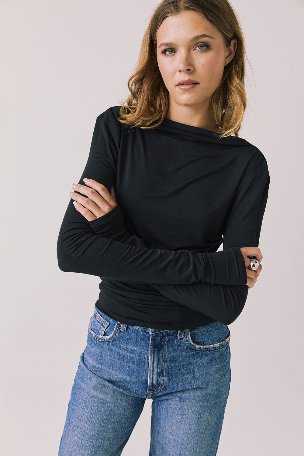 Front view of woman wearing Chaser’s Owen True Black Long Sleeve top with a relaxed fit and crew neckline on a light gray background