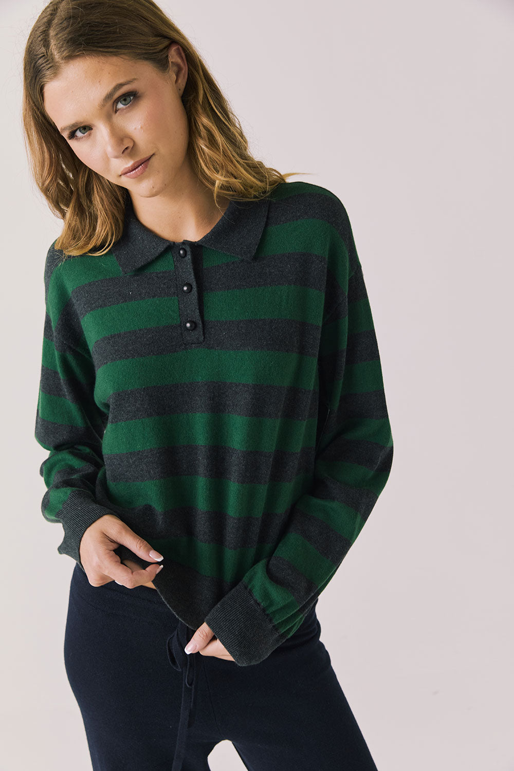 Front view of woman wearing Chaser’s Boyfriend Timeless Stripe Pullover with green and blue stripes on a plain background.