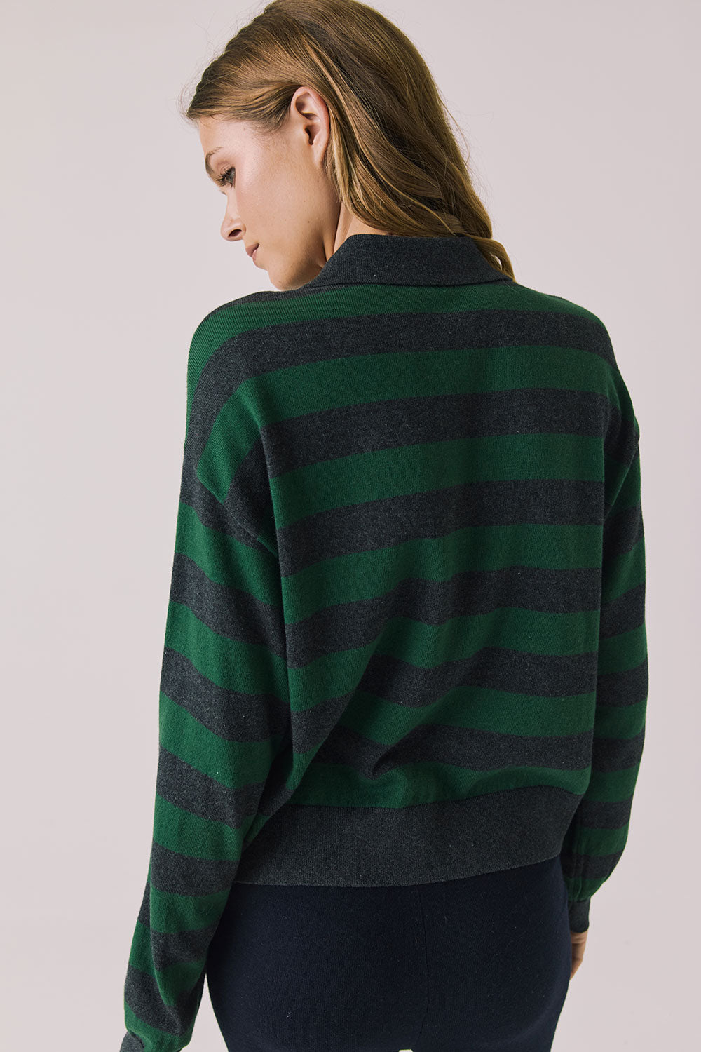 Back view of woman wearing Chaser’s Boyfriend Timeless Stripe Pullover with green and blue stripes on a plain background.