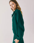 Side view of woman wearing Chaser’s City Blue Grass Green Half Zip Pullover with white drawstrings on a plain background