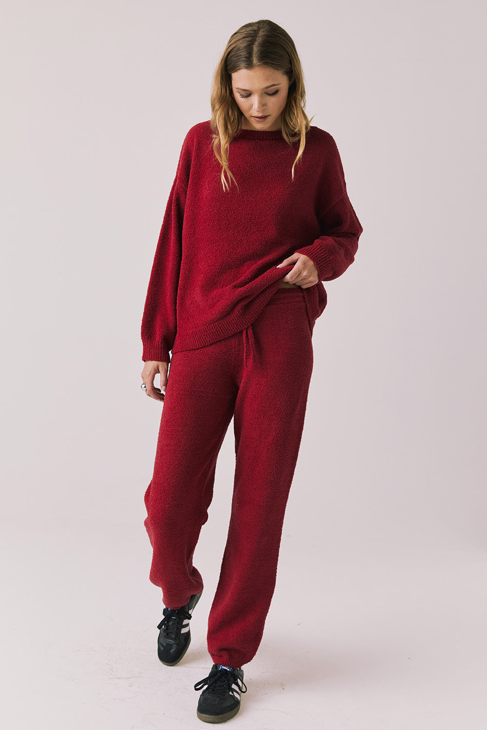 Full body view of woman wearing Chaser’s Miller Purple-Red Fig Pullover Sweater with matching Monica Purple-Red Fig Joggers on a white background