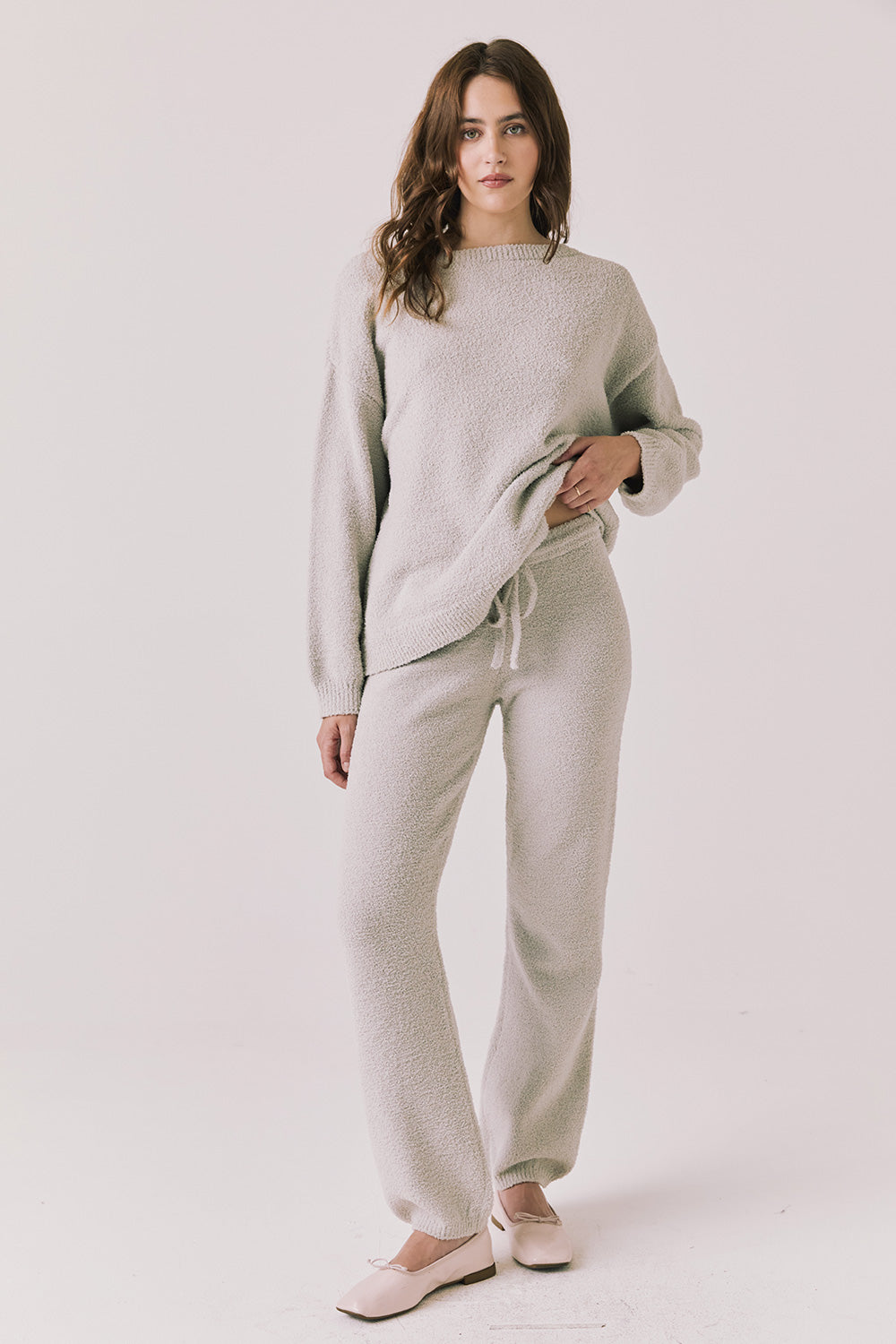 Full body view of woman wearing Chaser’s Miller Heather Grey Pullover Sweater with matching Monica Heather Grey Joggers on a white background