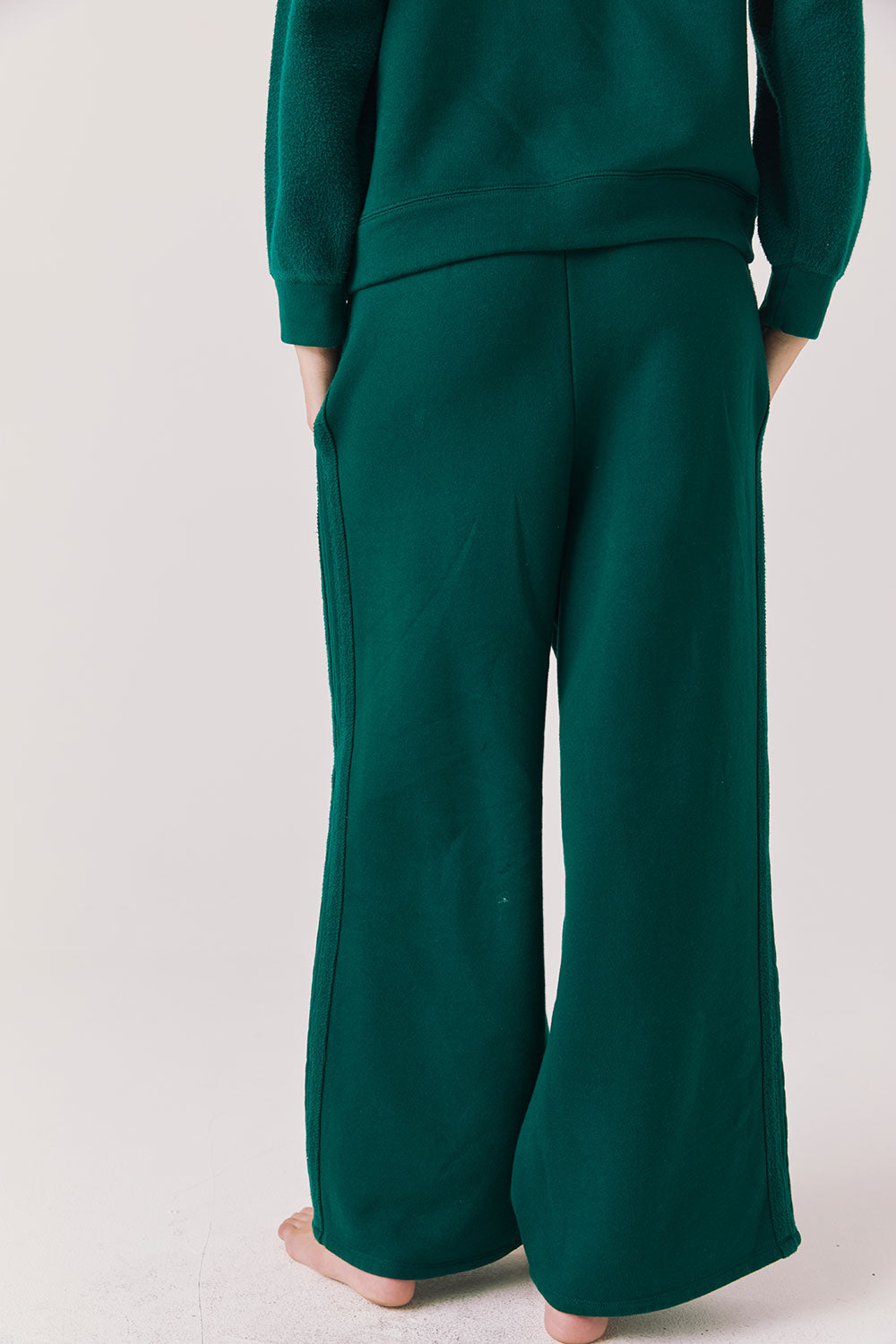 Back view of woman wearing Chaser’s Hazel Joggers in Blue Grass Green on a white background
