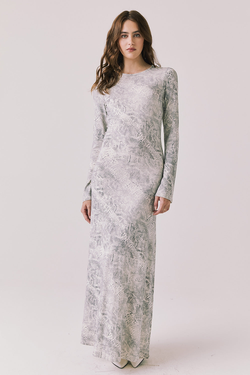 Full body view of woman wearing Chaser’s light Opal Python Print Maxi Dress with long sleeves, a subtle snakeskin design and relaxed fit against a white background
