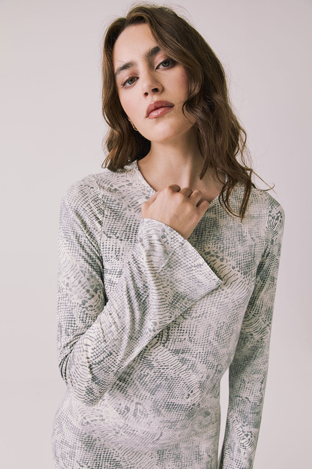 Front view of woman wearing Chaser’s light Opal Python Print Maxi Dress with with long sleeves and a subtle snakeskin pattern against a white background