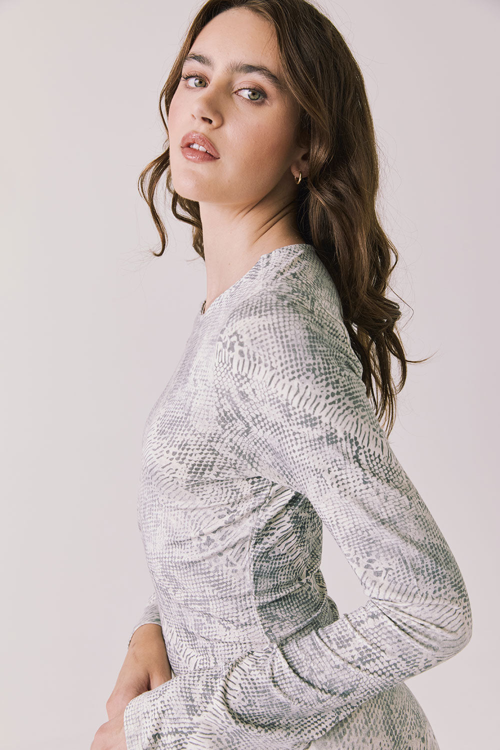 Side view of woman wearing Chaser’s light Opal Python Print Maxi Dress with with long sleeves and a subtle snakeskin pattern against a white background