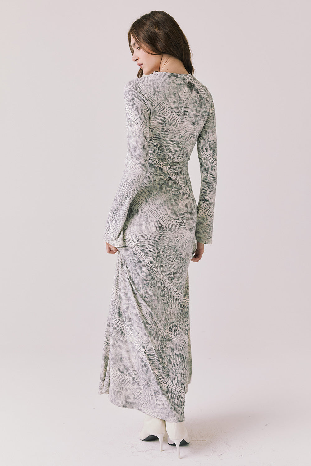 Full body back view of woman wearing Chaser’s light Opal Python Print Maxi Dress with long sleeves and relaxed fit against a white background