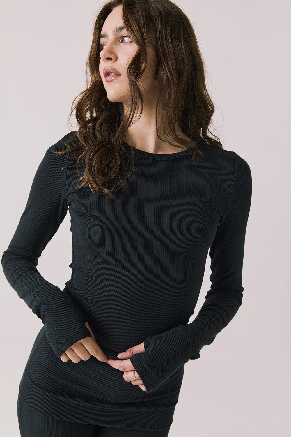 Front view of woman wearing Chaser’s Porta True Black Long Sleeve top on a white background