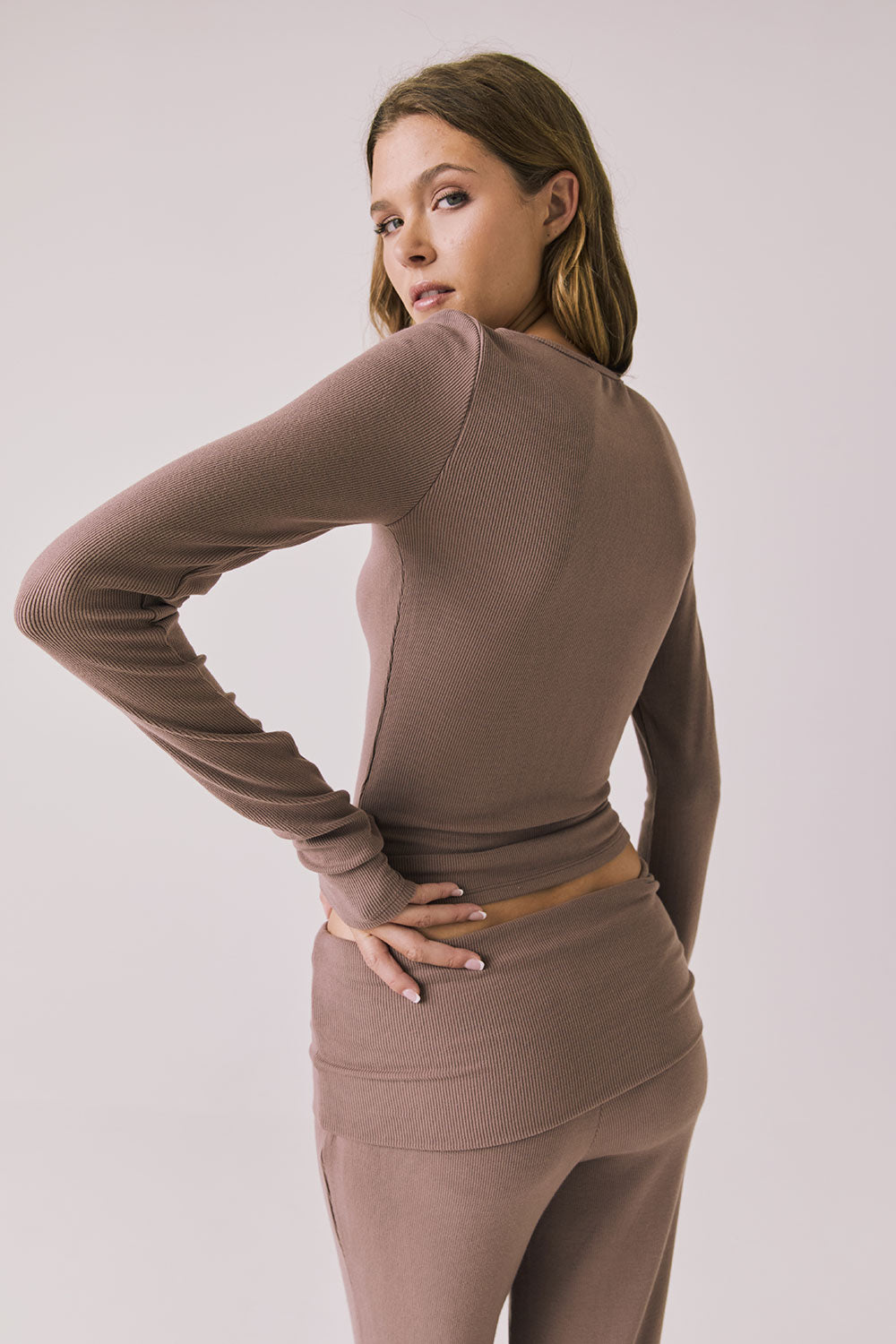 Back view of woman wearing Chaser’s Porta Deep Taupe Long Sleeve top on a white background