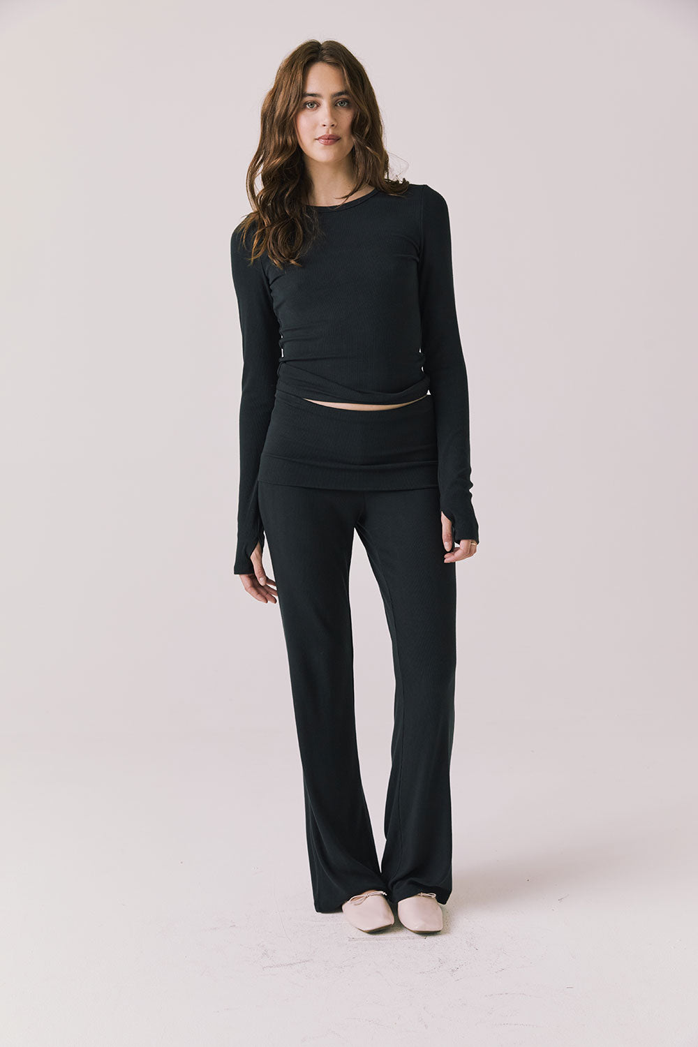 Full body view of woman wearing Chaser’s Porta True Black Long Sleeve top with matching Mantra True Black Legging on a white background