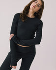 Front view of woman wearing Chaser’s Porta True Black Long Sleeve top on a white background