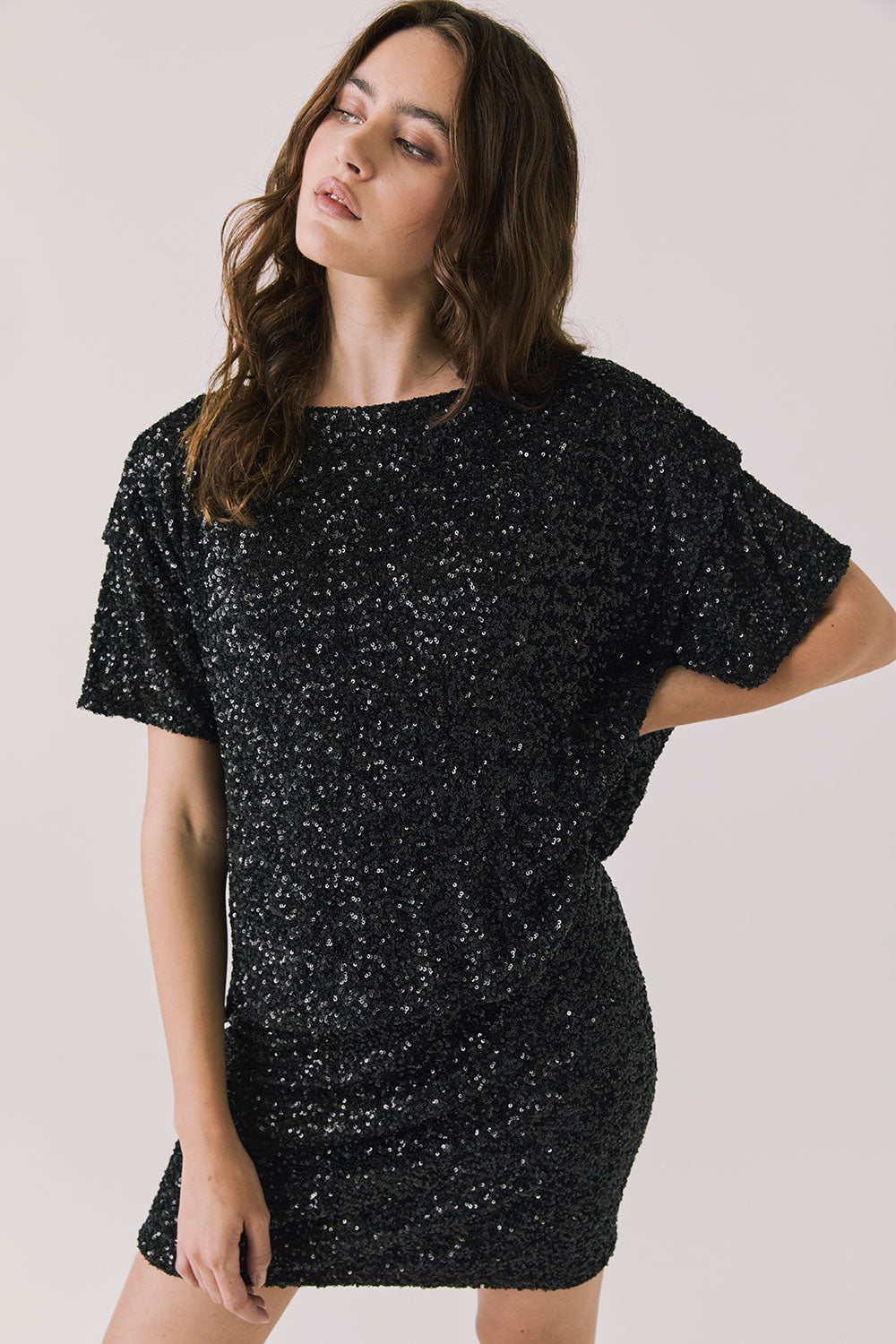 Front view of woman wearing Chaser’s Davis True Black Tee and matching Jayde True Black Mini Skirt on a light gray background