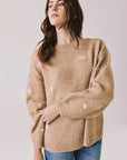 Front view of woman wearing Chaser’s Love Me Long Sleeve Beige Sweater on a plain background