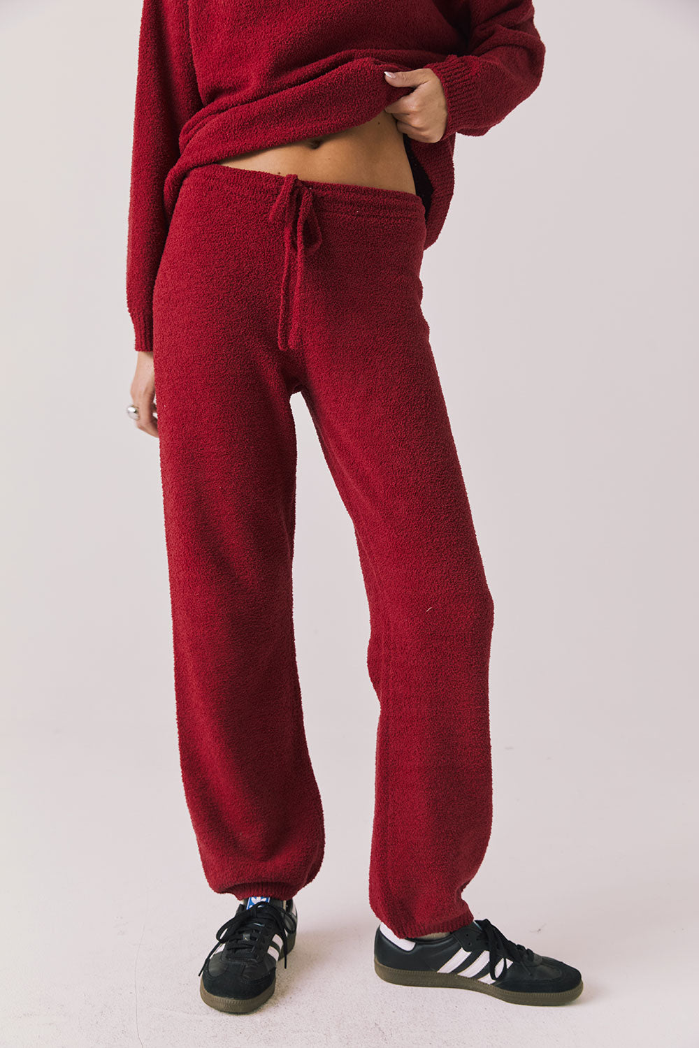 Front view of woman wearing Chaser’s Monica Purple-Red Fig Joggers on a white background