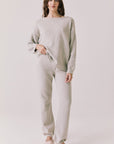 Full body view of woman wearing Chaser’s Monica Heather Grey Joggers with matching Miller Heather Grey Pullover Sweater on a white background
