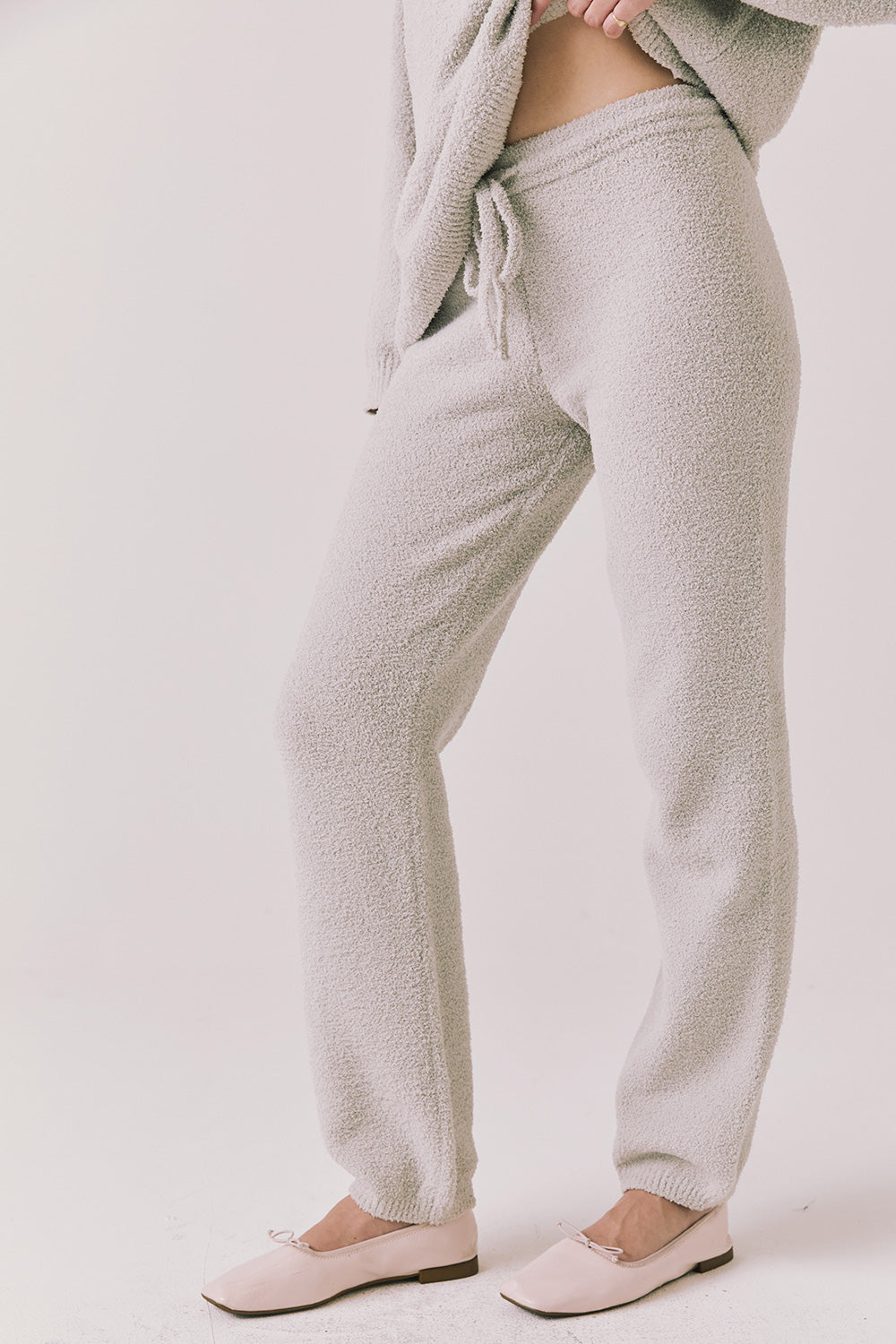 Side view of woman wearing Chaser’s Monica Heather Grey Joggers on a white background
