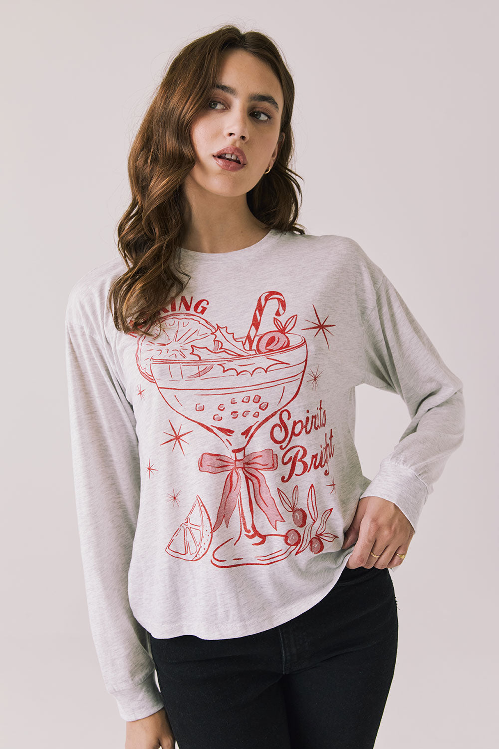 Front view of woman wearing Chaser’s Spirits Bright Light Grey Long Sleeve with red graphics and text on a light gray background